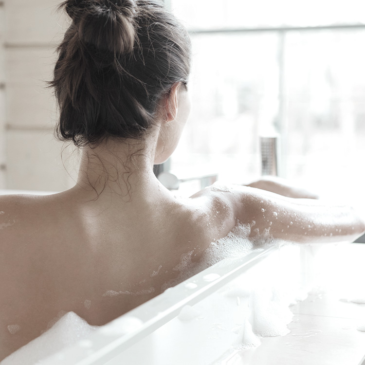 Mujer bañandose en una tina para cuidar su piel